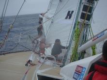 Taking Yankee down while Stay Sail remains up. They are pulling it down behind the Stay sail.